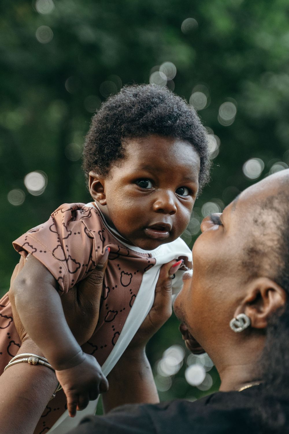 A mother lifting her baby up to her face